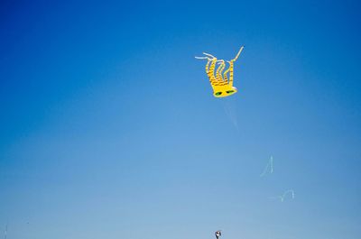 Low angle view of kite flying against blue sky