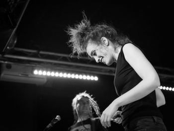 Side view of people playing at music concert