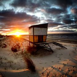 Scenic view of beach against dramatic sky