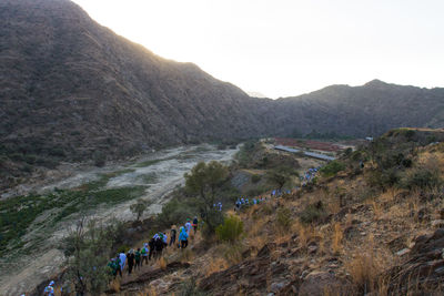 Panoramic view of people on landscape against sky