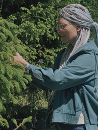 Side view of woman standing against plants