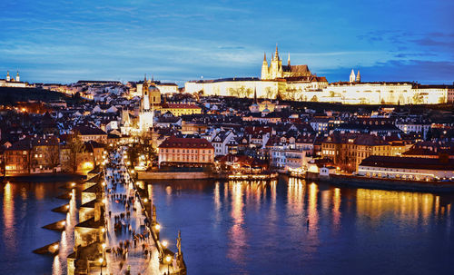 Illuminated buildings in city against sky