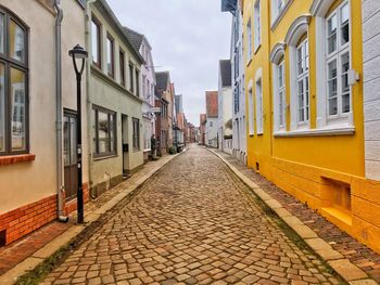 Empty alley amidst buildings in city