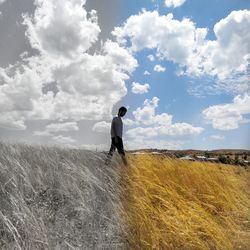 Rear view of man standing on field against sky