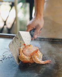 Close-up of man preparing prawns on frying pan