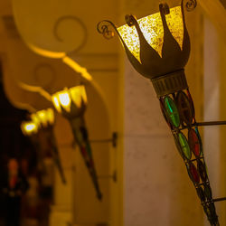 Low angle view of illuminated light bulbs hanging from ceiling