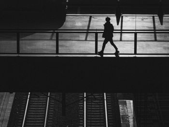 Low angle view of silhouette people walking on escalator