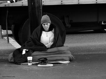 Homeless woman sitting on road