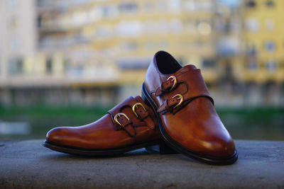 Close-up of brown shoes on retaining wall