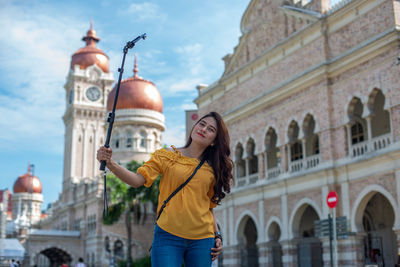 Woman standing by historic building