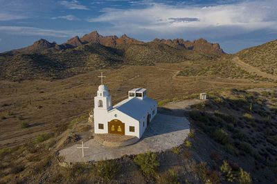 Traditional windmill on mountain against sky, church