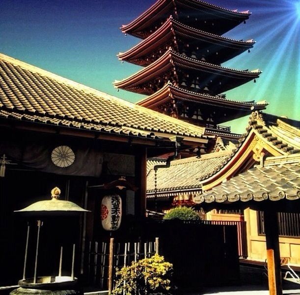 building exterior, architecture, built structure, place of worship, religion, low angle view, spirituality, temple - building, roof, house, tradition, clear sky, residential building, pagoda, sunlight, temple, cultures, sky, outdoors