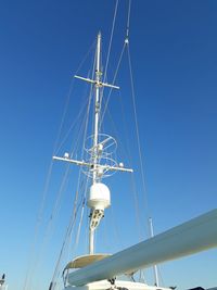 Low angle view of sailboat against clear blue sky