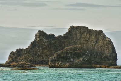 Scenic view of rock formation in sea against sky