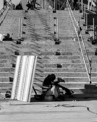 Woman sitting on street in city