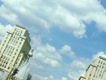 Low angle view of buildings against cloudy sky