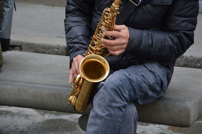 Midsection of man playing musical instrument