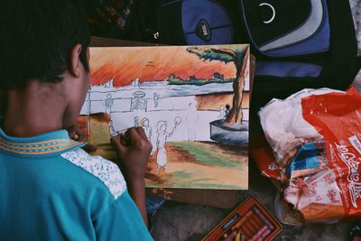 Portrait of boy holding multi colored painting