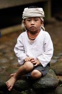 Boy sitting on rock