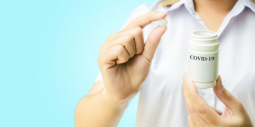 Midsection of person holding hands against white background