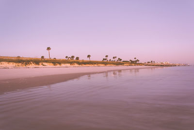 Scenic view of lake against clear sky during sunset