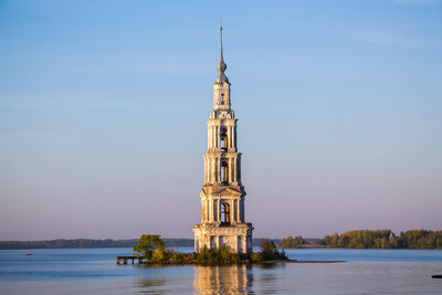 Beautiful christian church with golden domes among green trees.