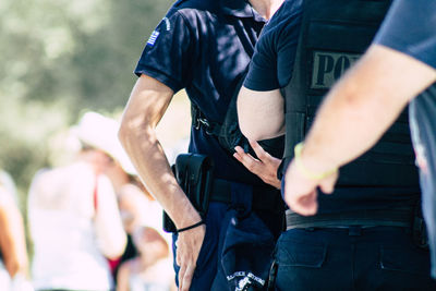 Midsection of man holding camera while standing outdoors