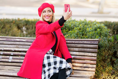 Woman taking selfie sitting on bench