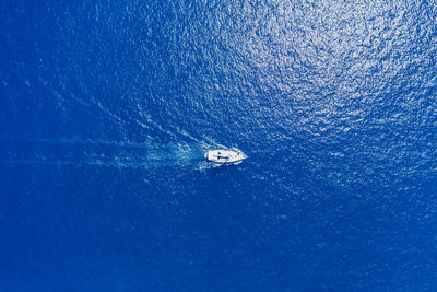 Low angle view of sailboat on sea against blue sky