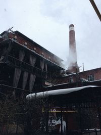 Low angle view of factory against sky