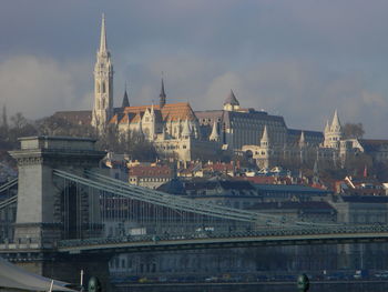 Buildings in city against cloudy sky