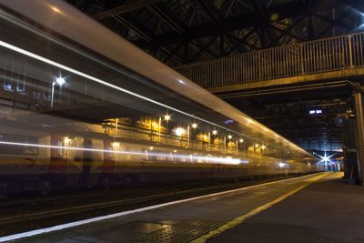 Illuminated railroad station platform at night