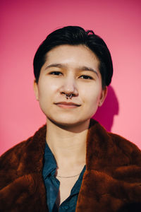 Portrait of young man against red background