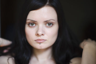 Close-up portrait of young woman at home