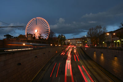 Light trails on road against sky in city at night