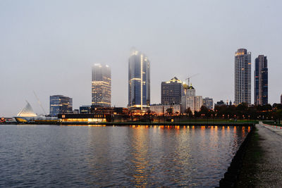 City at waterfront against clear sky