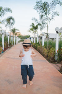 Full length of boy standing by trees against plants