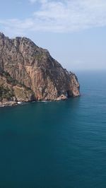 Scenic view of sea and mountains against sky