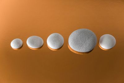 High angle view of pebbles arranged over orange background