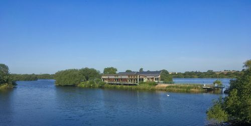 Scenic view of lake against clear blue sky