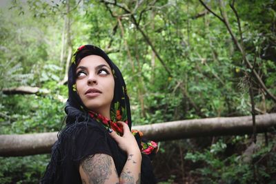 Woman wearing scarf in forest