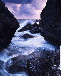 Scenic view of rocks in sea against sky
