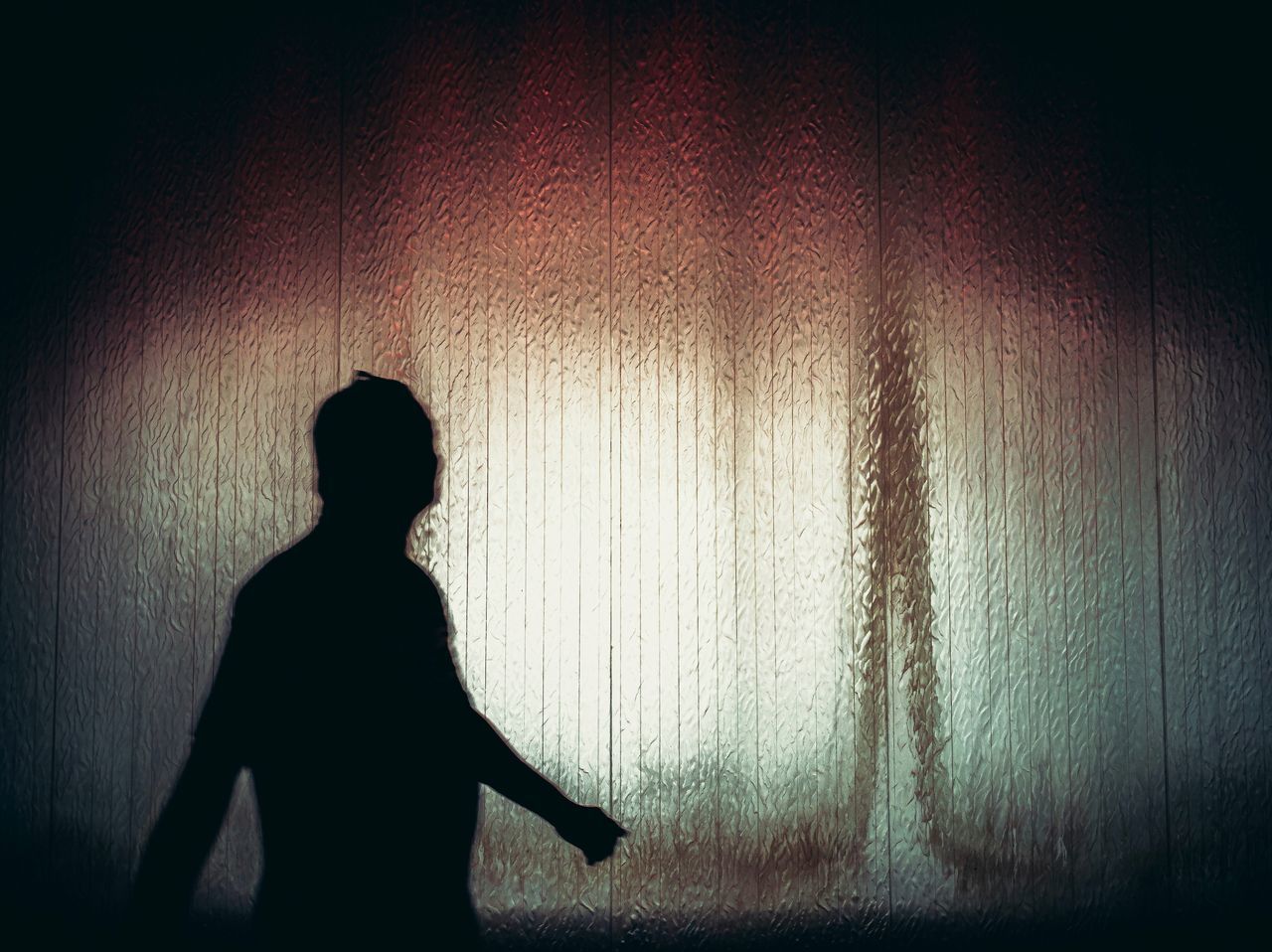 REAR VIEW OF SILHOUETTE WOMAN STANDING AGAINST CURTAIN