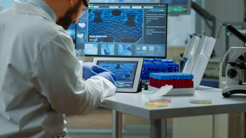 Midsection of scientist working at laboratory