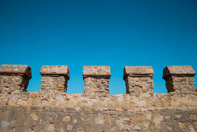 Low angle view of old wall against blue sky