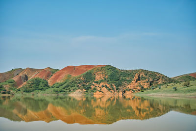 Breathtaking unearthly landscape of mountain lake and view of red mountains