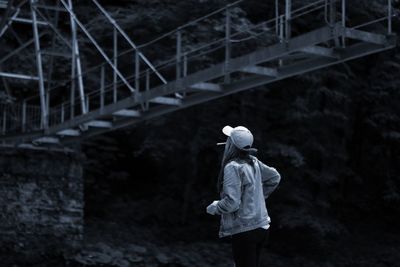 Woman standing below footbridge