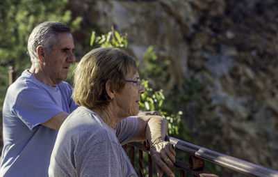 Rear view of friends on railing against blurred background