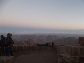 Rear view of man standing on landscape against sky