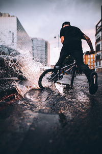 Man riding bicycle in water against sky